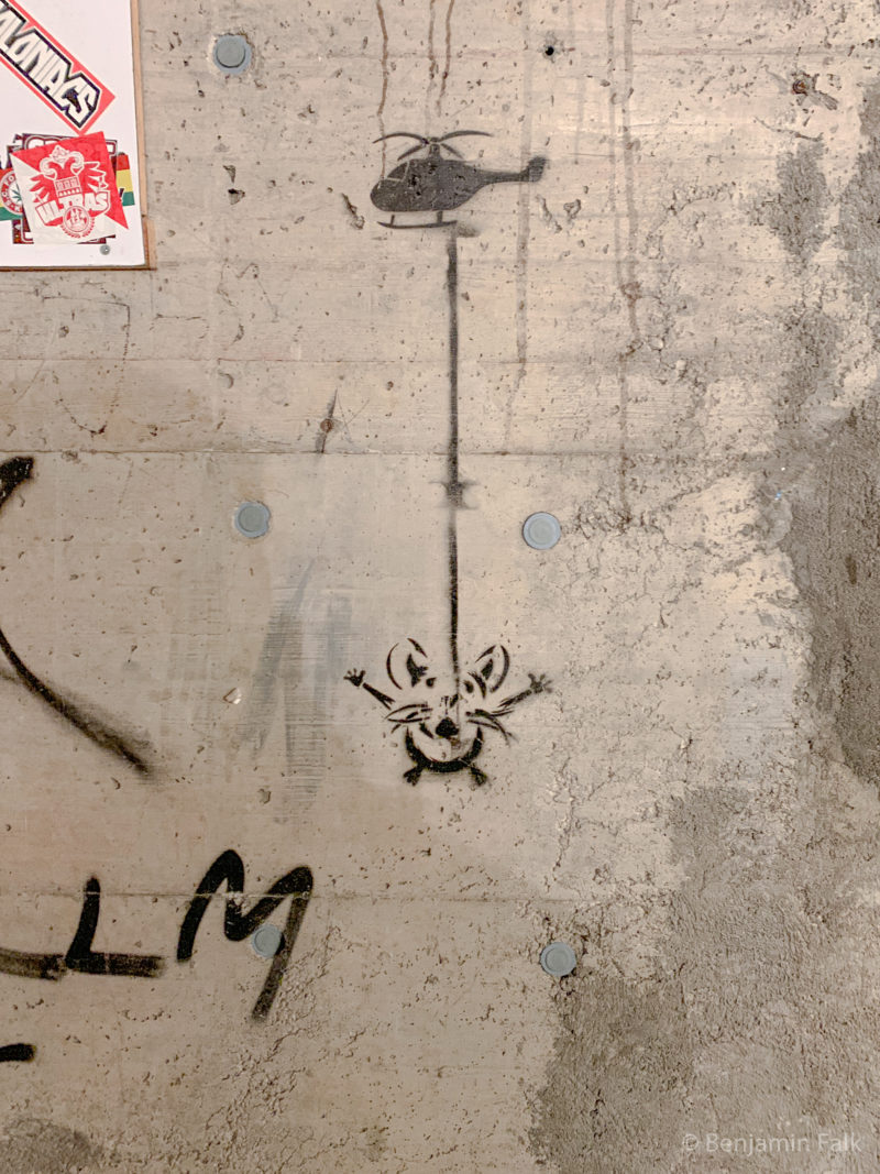 Graffiti einer Maus an einem helikopter auf einer Sicht-Beton-Wand.