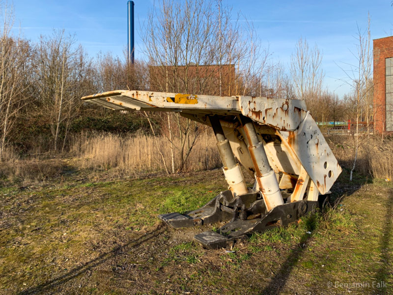 Hydraulische Stütze aus dem Bergbau, verrostet auf einem Aussengelände stehend.