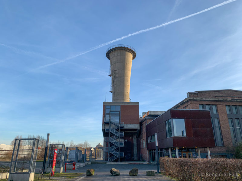 Kühlturm eines umgenutzen Zechengebäudes, vor einem blauen Himmel