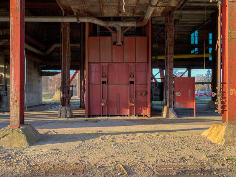 Aufbau auf einem Zechen-Förderschacht, unter einem Gebäude mit roten Stahlträgern, in einem entkernten Gebäudebereich.