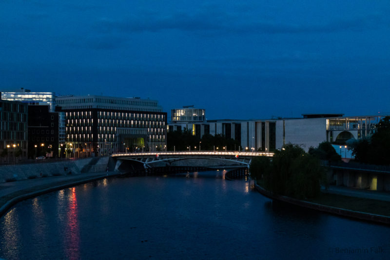 Beleuchtete Brücke in der Abenddämmerung über die Spree am Reichstagsofer mit Blick auf die Bundestagsgebäude und die Bundespressekonfernez.